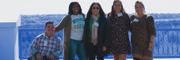 Four alumni posing and smiling for the camera.