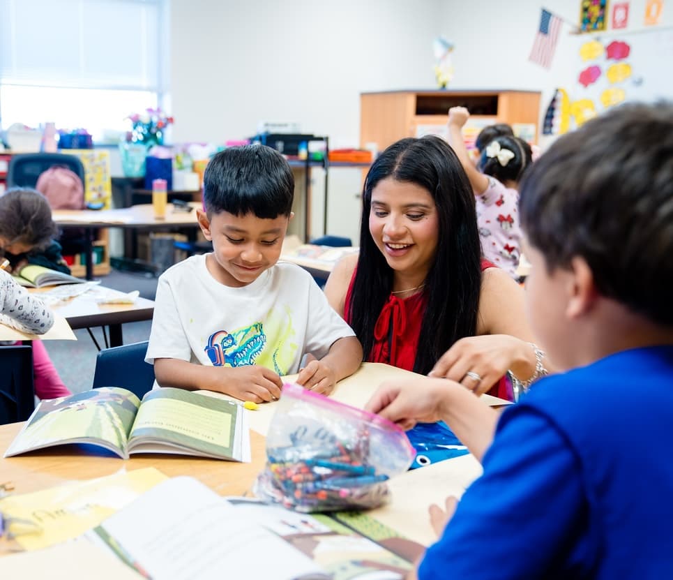 young teacher with student in classroom