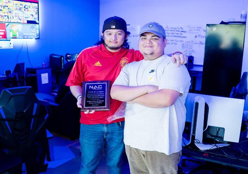 Jonathan Suarez (in red) and an eSports Teammate Holding Their Call of Duty Championship Plaque