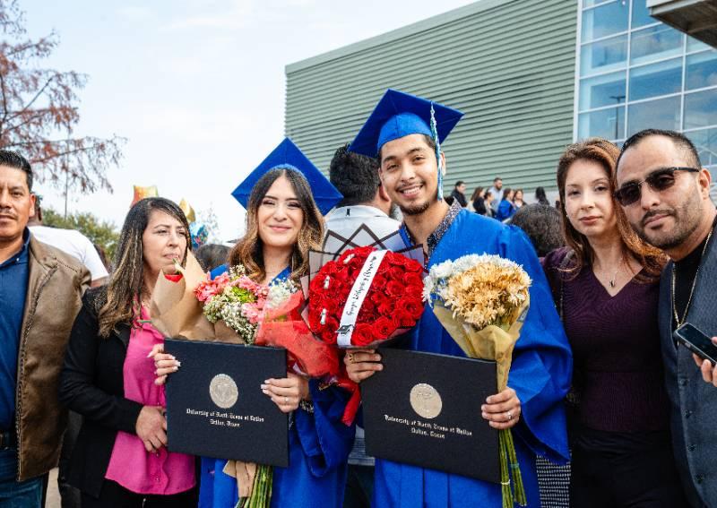 Two Graduates and Their Families Celebrate After Commencement Ceremonies
