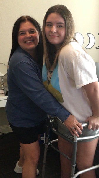 Maddie Mansell Standing with Her Walker and Mother, The First Time She Stood Up After Her Accident