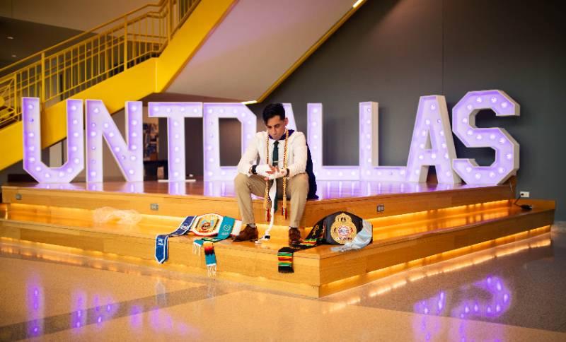 Noe Mendoza Jr Reflects on His UNT Dallas College of Law Experience While Sitting with His Championship Belts from National Collegiate Boxing Victories