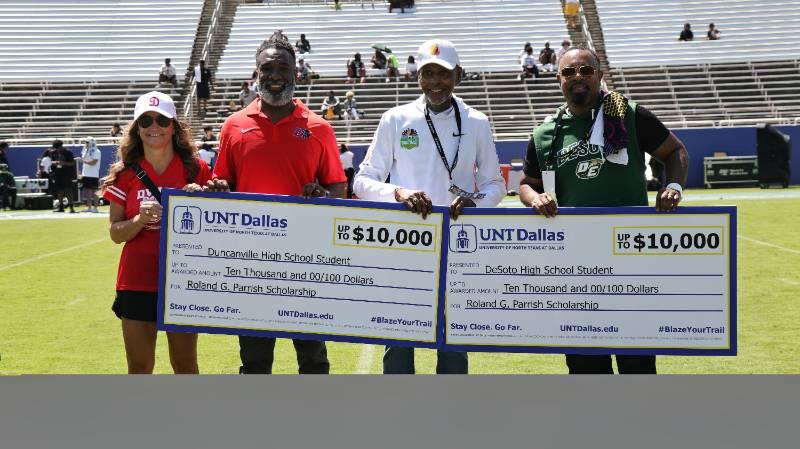 Roland Parrish (second from right) with Duncanville Head Coach Reginald Samples and DeSoto Head Coach Claude Mathis Holding Two Checks for $10,000 Scholarships to UNT Dallas