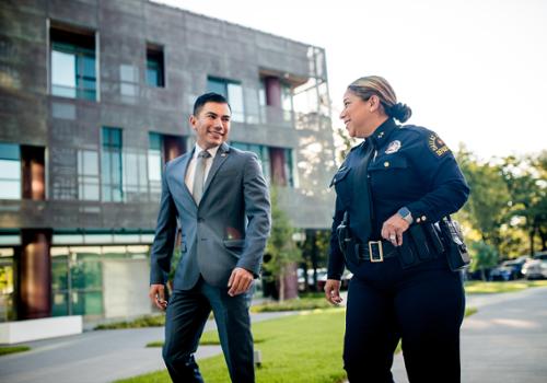 police woman and man walking in courtyard