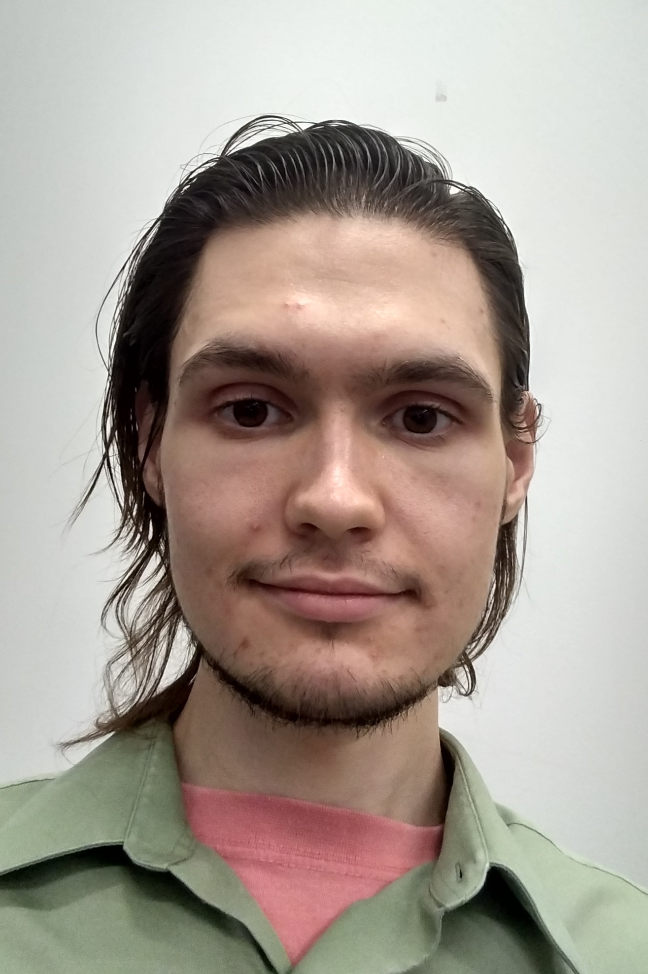 man with long hair in a green button up shirt