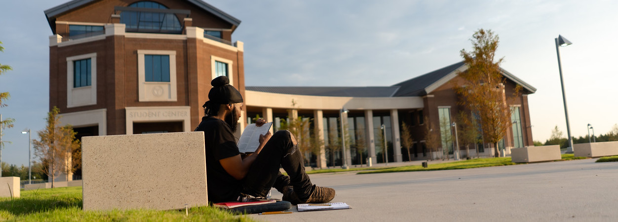 student sitting in student center courtyard