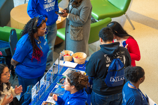 Students exploring a table with flyers.